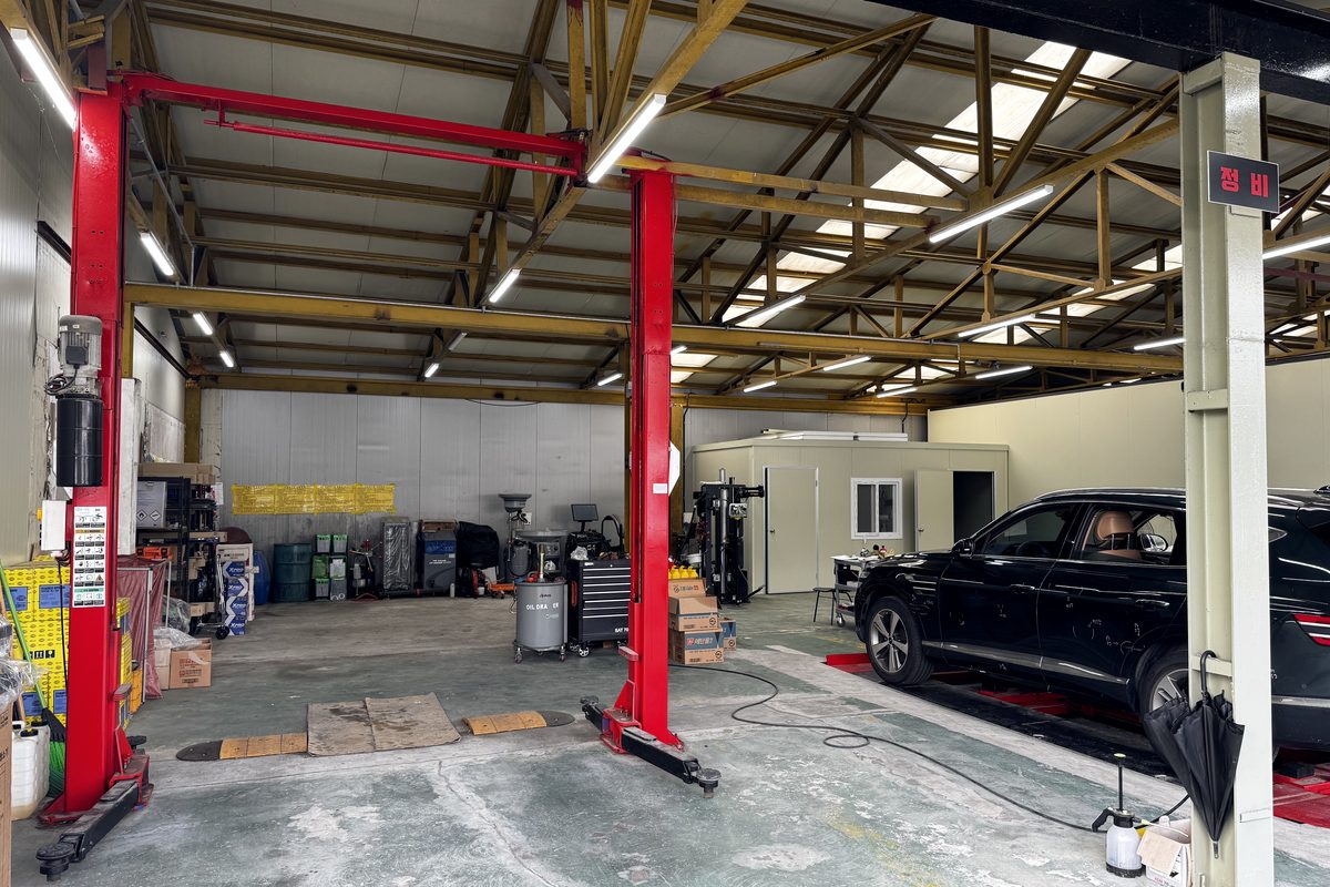 Service garage with two-post lifts, where cars are inspected and shot from underneath